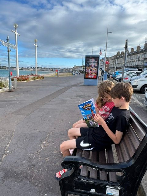 Harrison and Eliana reading Book 1 in Weymouth 🏴